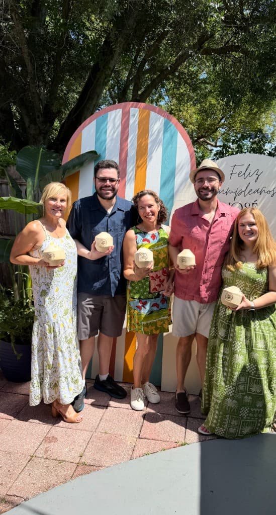 Guests holding engraved Yaad Coco coconuts at an outdoor event