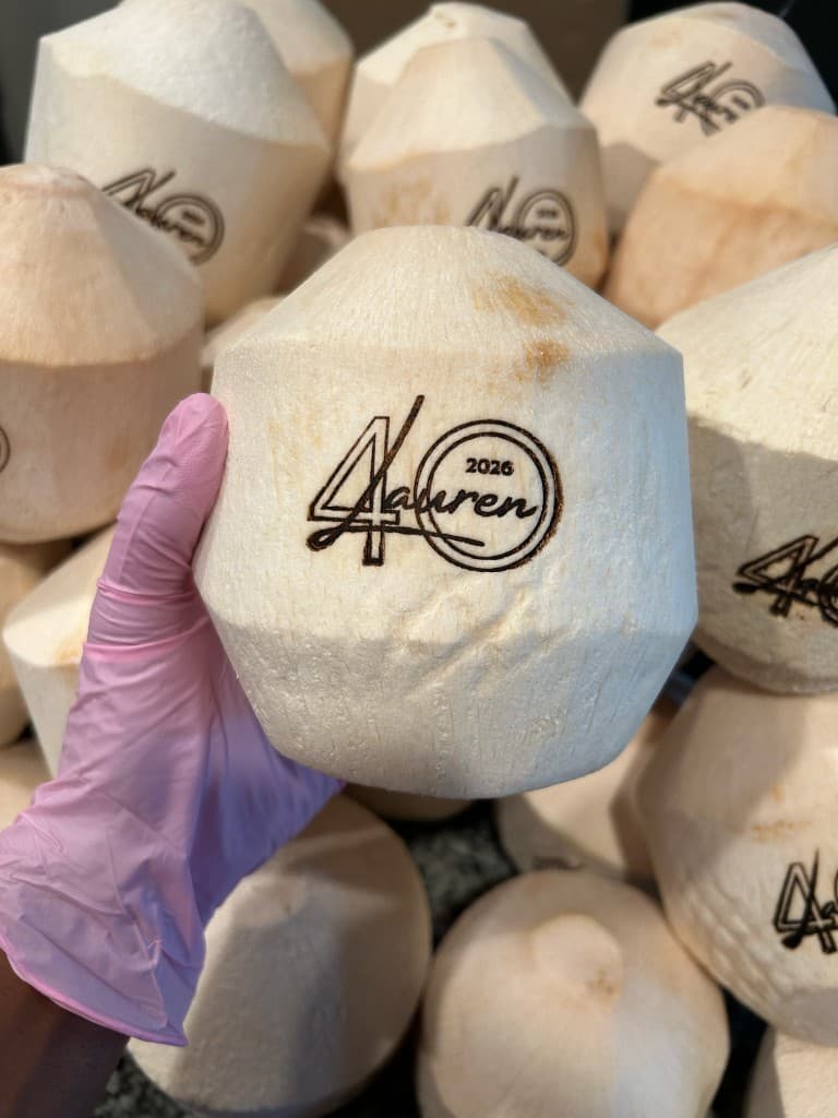 Stack of custom engraved coconuts for a milestone celebration
